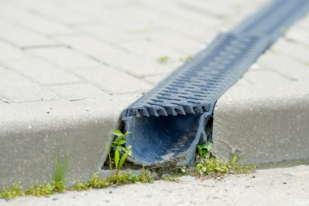 Caniveau d’évacuation des eaux de pluie intégré à une voirie en pavés