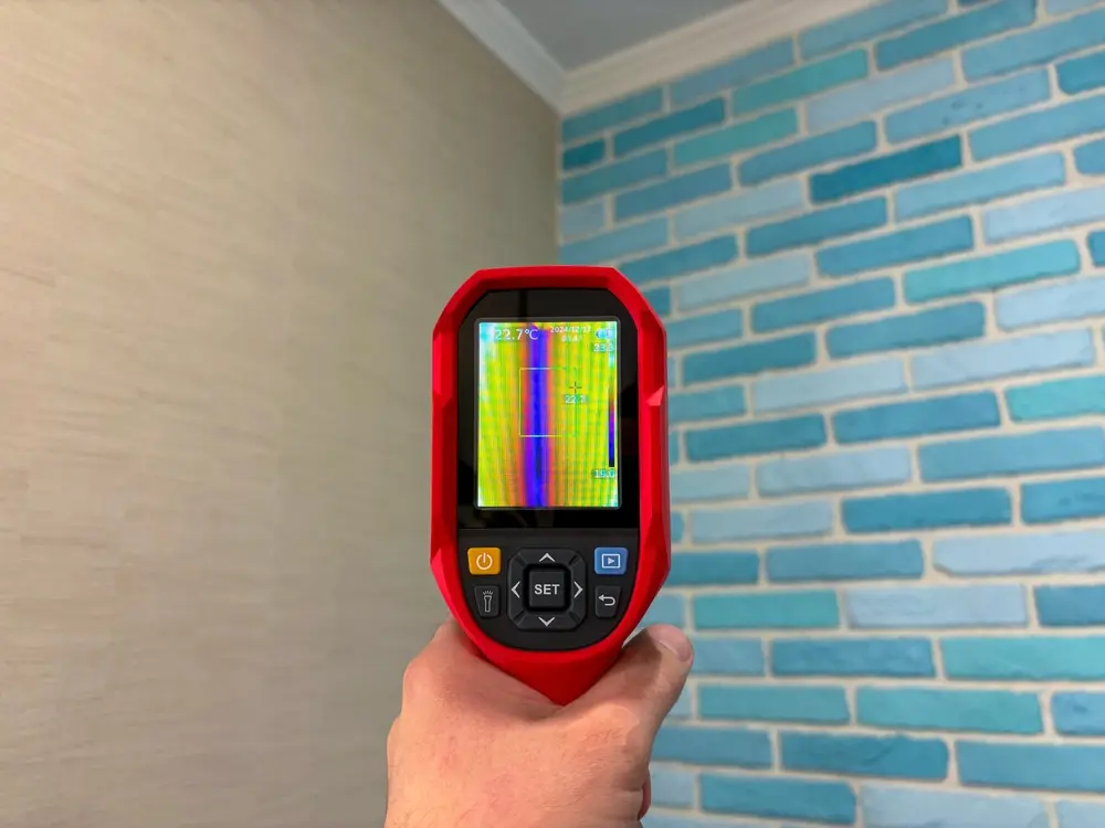Caméra thermique pointée vers un mur intérieur pour détecter un pont thermique linéique invisible à l’œil nu