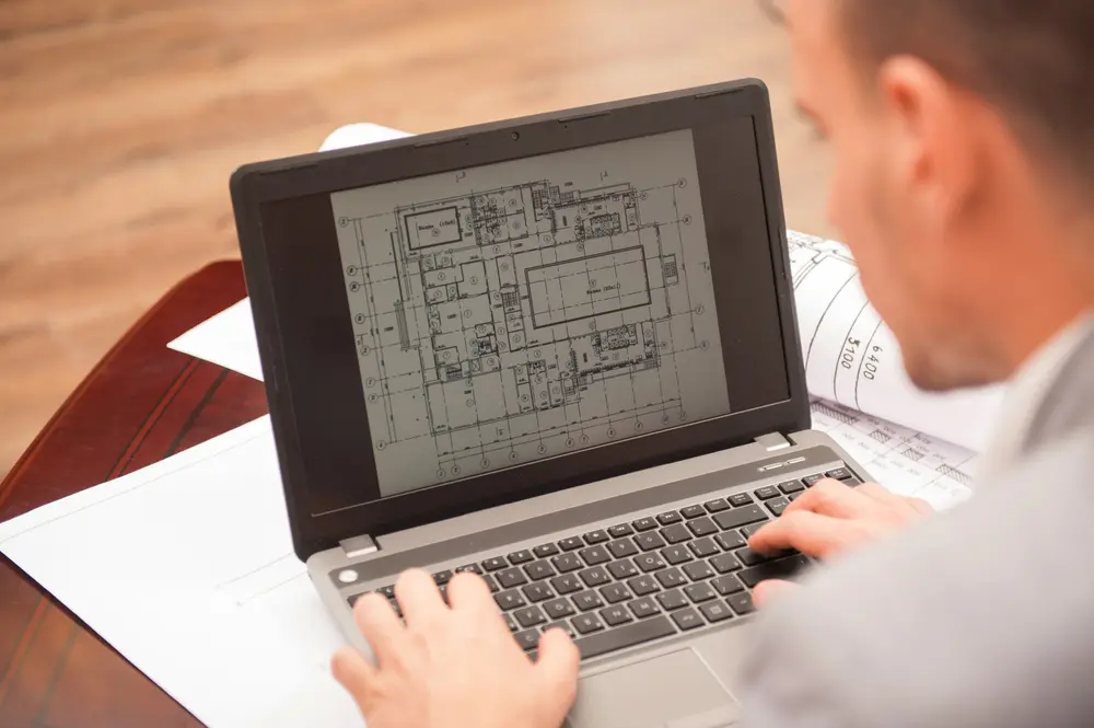 Ingénieur d'un bureau d'étude structure réalisant une note de calcul sur plans